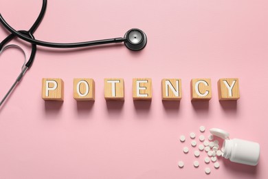 Word Potency made of wooden cubes, stethoscope and pills on light pink background, flat lay