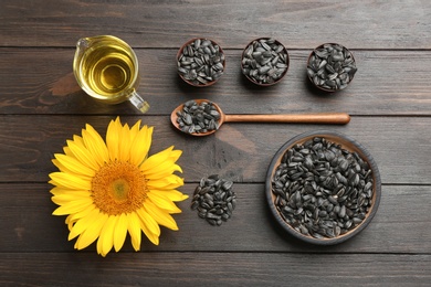 Flat lay composition with sunflower seeds and flower on wooden table