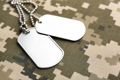 Military ID tags on camouflage background