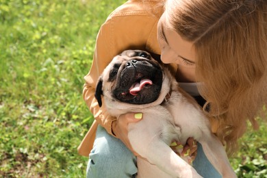 Photo of Woman with cute pug dog outdoors on sunny day. Animal adoption