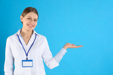 Portrait of young doctor on blue background, space for text