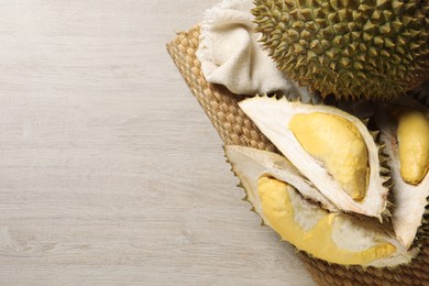 Fresh ripe durians on light wooden table, top view. Space for text