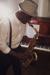 African-American man playing saxophone indoors. Talented musician