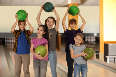 Happy children with balls in bowling club