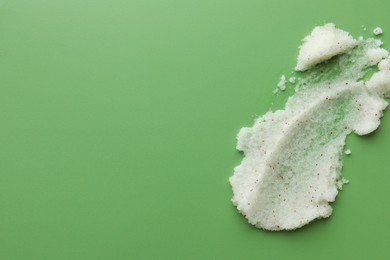 Sample of body scrub on green background, top view. Space for text