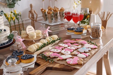 Baby shower party. Different delicious treats on wooden table indoors