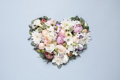 Photo of Beautiful heart made of different flowers on light gray background, top view