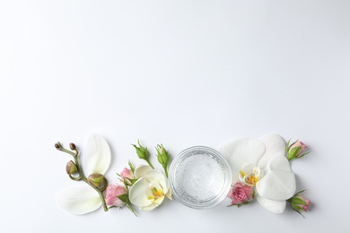 Composition with cosmetic gel and beautiful flowers on white background, top view