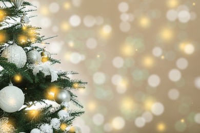Beautiful Christmas tree with bright baubles against blurred lights on golden background, closeup. Space for text