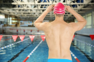 Young athletic man standing near swimming pool