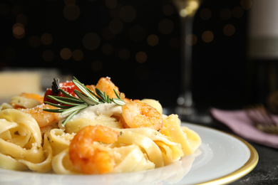 Photo of Delicious pasta with shrimps on black background, closeup