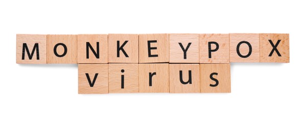 Photo of Words Monkeypox Virus made of wooden squares with letters on white background, top view