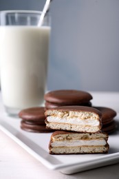 Tasty choco pies and milk on white wooden table