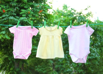 Baby clothes on laundry line outdoors on sunny day
