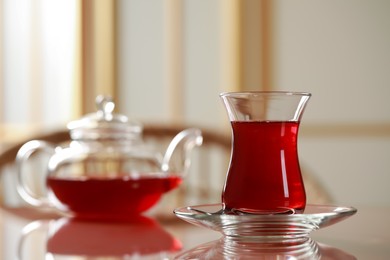 Photo of Glass of traditional Turkish tea on table indoors. Space for text