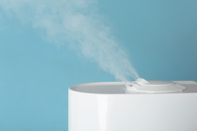 Modern air humidifier on light blue background, closeup. Space for text