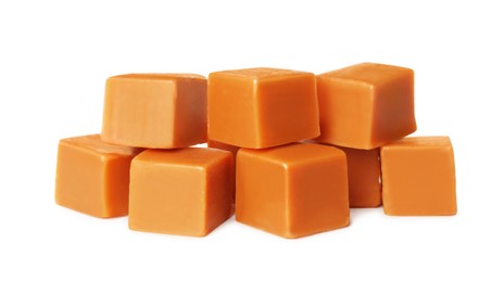 Many caramel cubes on white background. Confectionery