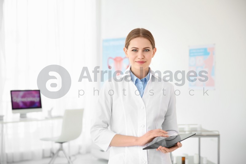 Young female doctor with tablet in modern hospital. Gynecology consultation
