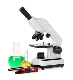 Photo of Laboratory glassware with colorful liquids and microscope isolated on white
