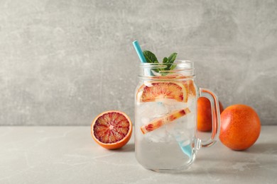 Delicious refreshing drink with sicilian orange and mint on grey table. Space for text