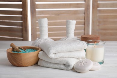 Photo of Spa composition with skin care products and burning candle on white wooden table