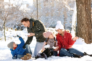 Photo of Happy family having fun in winter park