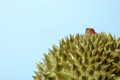 Fresh ripe durian on light blue background, closeup. Space for text