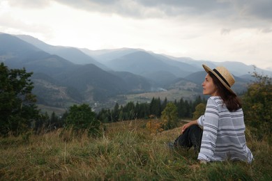 Woman enjoying beautiful mountains landscape. Space for text