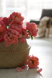 Beautiful bouquet of fragrant peonies on floor indoors