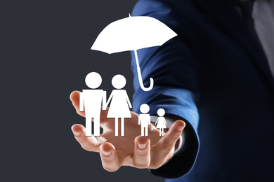 Insurance concept - umbrella demonstrating protection. Man with illustrations on dark background, closeup