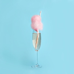 Cocktail with cotton candy in glass on light blue background