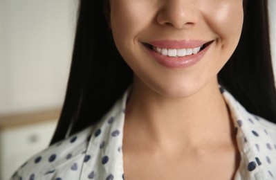 Young woman with healthy teeth on blurred background, closeup