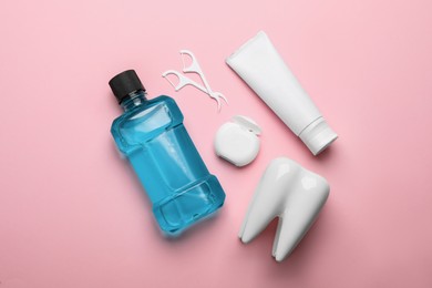 Flat lay composition with mouthwash and other oral hygiene products on pink background