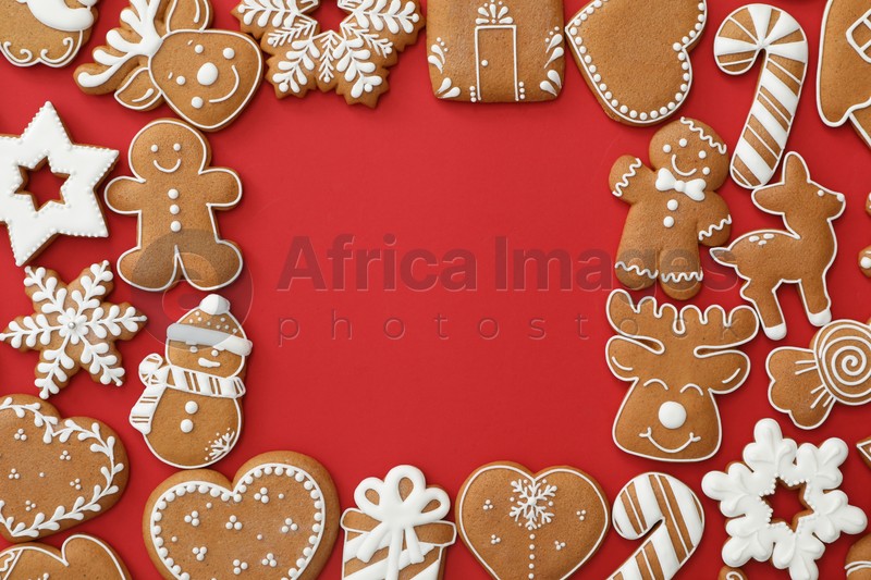 Frame made with different Christmas gingerbread cookies on red background, flat lay. Space for text