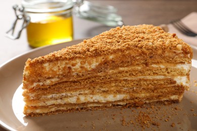 Photo of Slice of delicious layered honey cake on plate, closeup