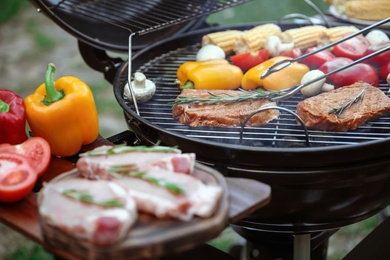 Photo of Cooking fresh food on barbecue grill outdoors, closeup