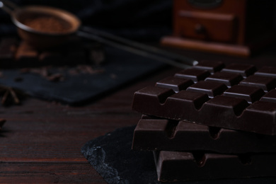 Tasty dark chocolate bars on wooden table, closeup