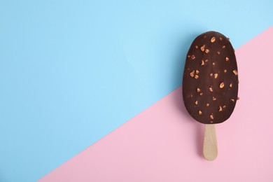 Ice cream glazed in chocolate on color background, top view. Space for text