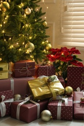 Many different gifts under Christmas tree indoors