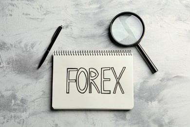 Notebook with word Forex, magnifying glass and pen on light table, flat lay