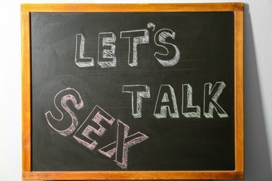 Small blackboard with written phrase "LET'S TALK SEX". School education
