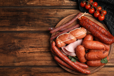 Different tasty sausages on wooden table, top view. Space for text