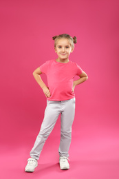 Cute little girl posing on pink background