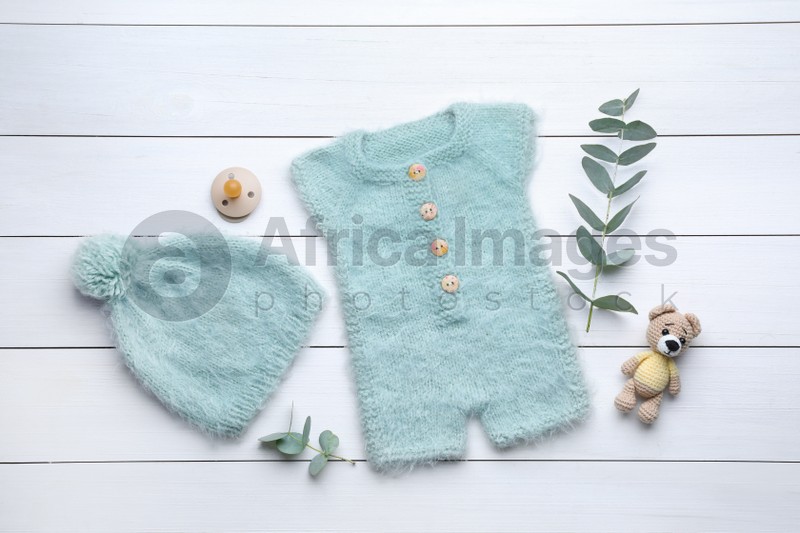 Flat lay composition with child's clothes and accessories on white wooden table