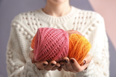 Woman holding clews of knitting threads, closeup
