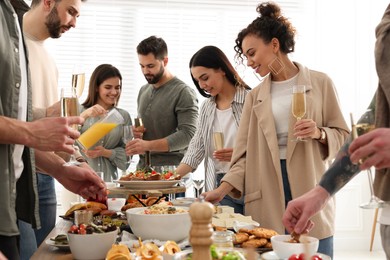 Photo of Group of people enjoying brunch buffet together indoors