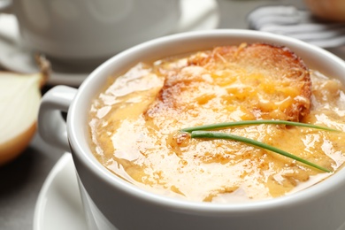 Tasty homemade french onion soup on table, closeup