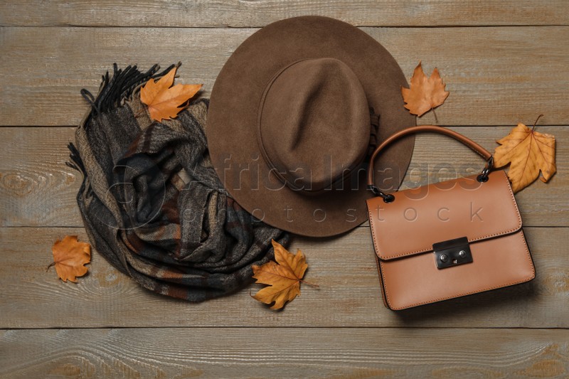 Photo of Flat lay composition with hat and dry leaves on wooden background. Autumn season