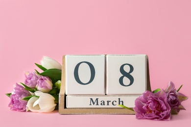 Wooden block calendar with date 8th of March and tulips on pink background, space for text. International Women's Day