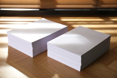 Photo of Stacks of paper sheets on wooden table